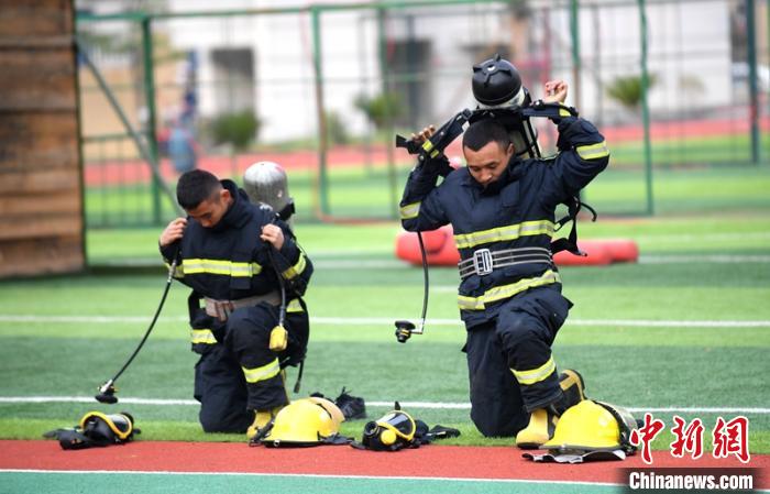 新消防員進(jìn)行穿戴空呼器展示?！⒅铱?攝