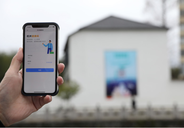 在浙江省杭州市臨安區(qū)天目山鎮(zhèn)，一名居民在“杭州健康碼”海報(bào)上掃碼申領(lǐng)個(gè)人二維碼。新華社發(fā)