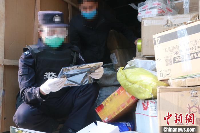 圖為勐康邊檢站民警在對(duì)快遞運(yùn)輸車輛進(jìn)行例行檢查?！钐?攝