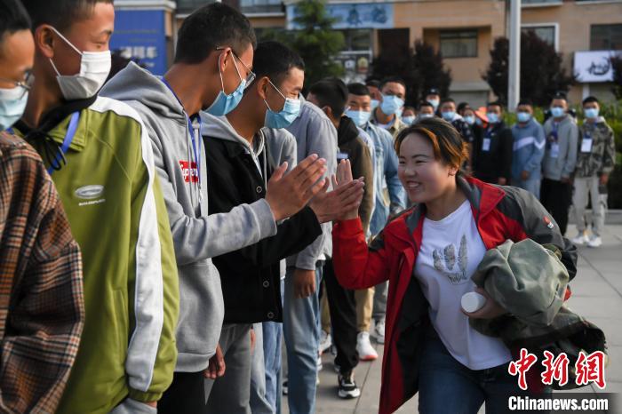 7月7日，拉薩三高考點外，領(lǐng)隊老師與考生擊掌鼓勁加油?！『闻罾?攝